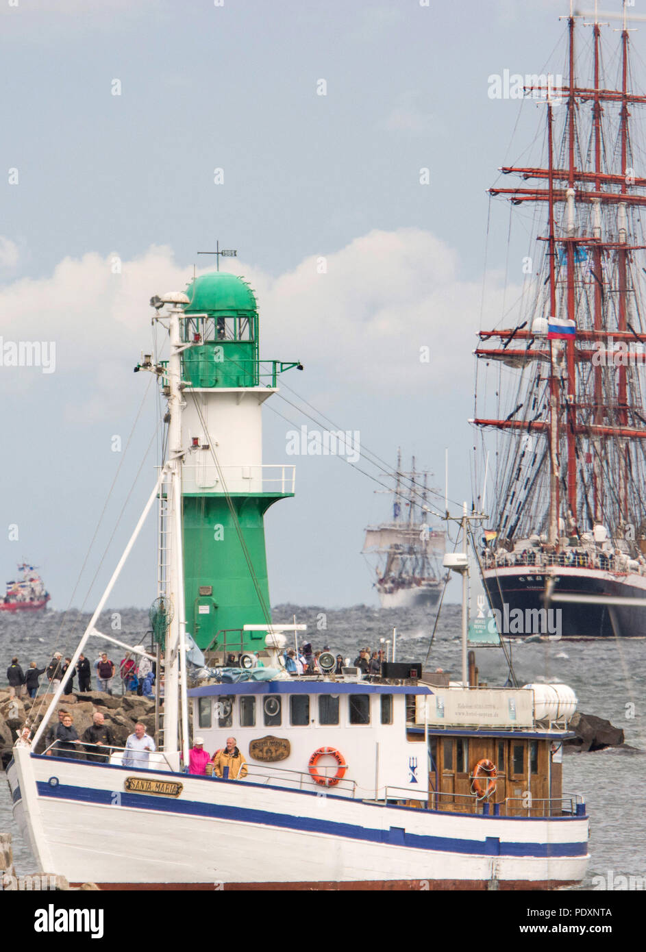 Rostock, Germany. 11th Aug, 2018. Tall ships, traditional ships and excursion steamers sail off the Warnemuende pier for the traditional cruise of the Hanse Sail on Saturday, in the picture on the right the 117 meter long four-masted barque 'Sedow' sailing under the Russian flag. Credit: Frank Hormann/dpa/Alamy Live News Stock Photo