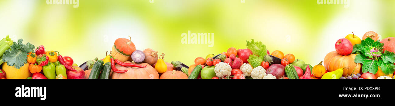 Wide collage of fresh fruits and vegetables on green blur background. Copy space. Stock Photo