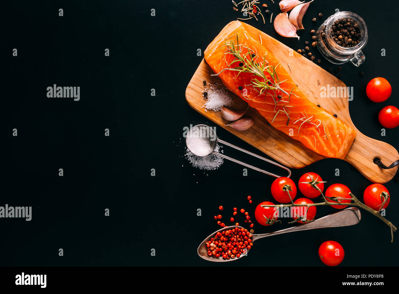 Delicious Salmon fillet with various spices on black background Stock Photo