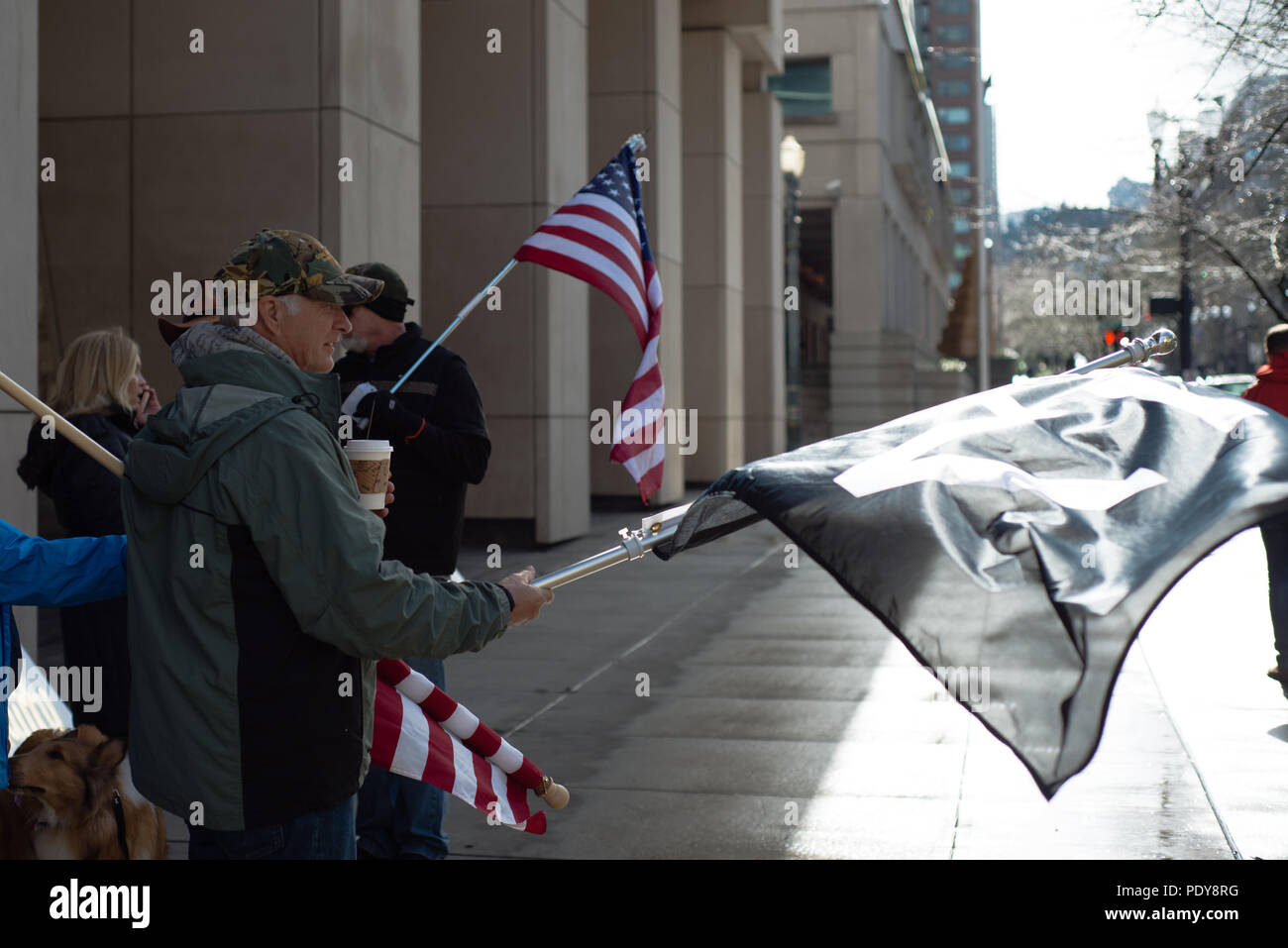 Man in front of the courthouse with a flag protesting the second trial of participants of the occupation of the Malheur Wildlife Refuge and the death Stock Photo