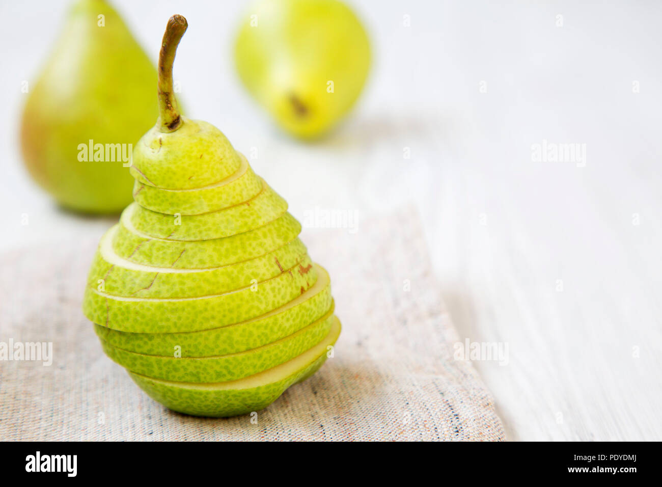 Sliced fresh pear on cloth, closeup. Side view. Copy space. Stock Photo