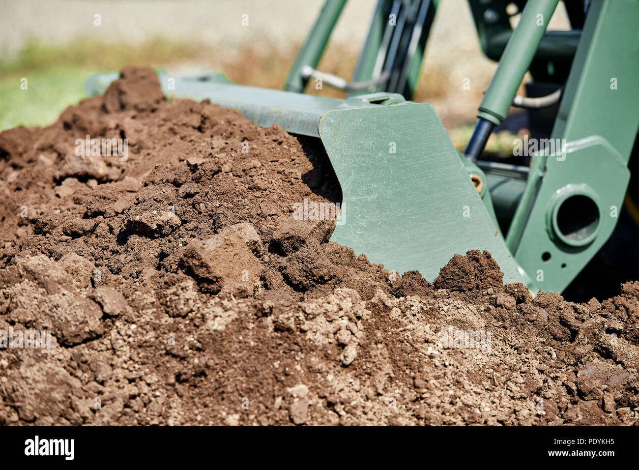 Close up of a tractor bucket shoveling a pile of dirt Stock Photo Alamy