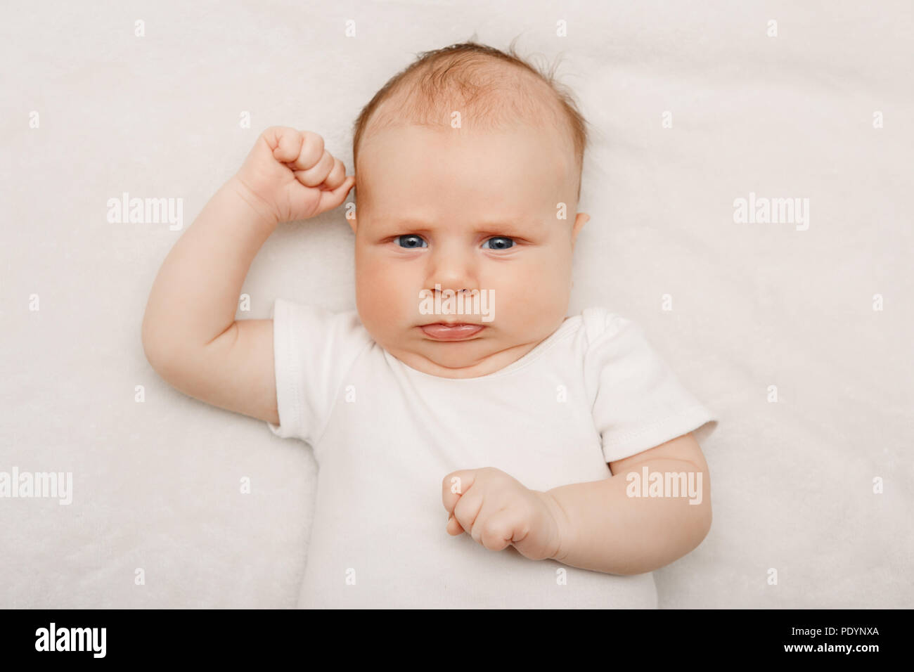 Closeup portrait of adorable funny white Caucasian baby with blue grey