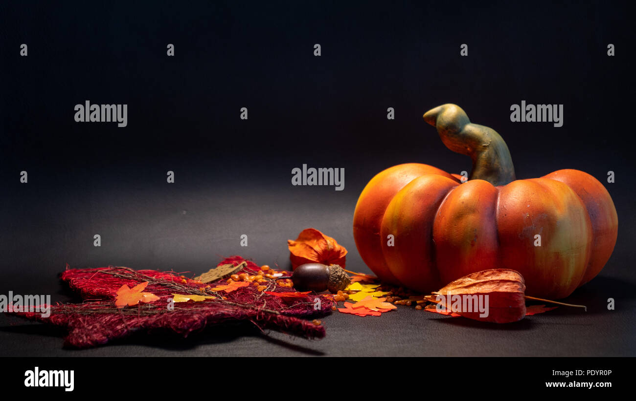autumn fall decoration scene with artificial pumpkin leaves in orange color on black background studio Stock Photo