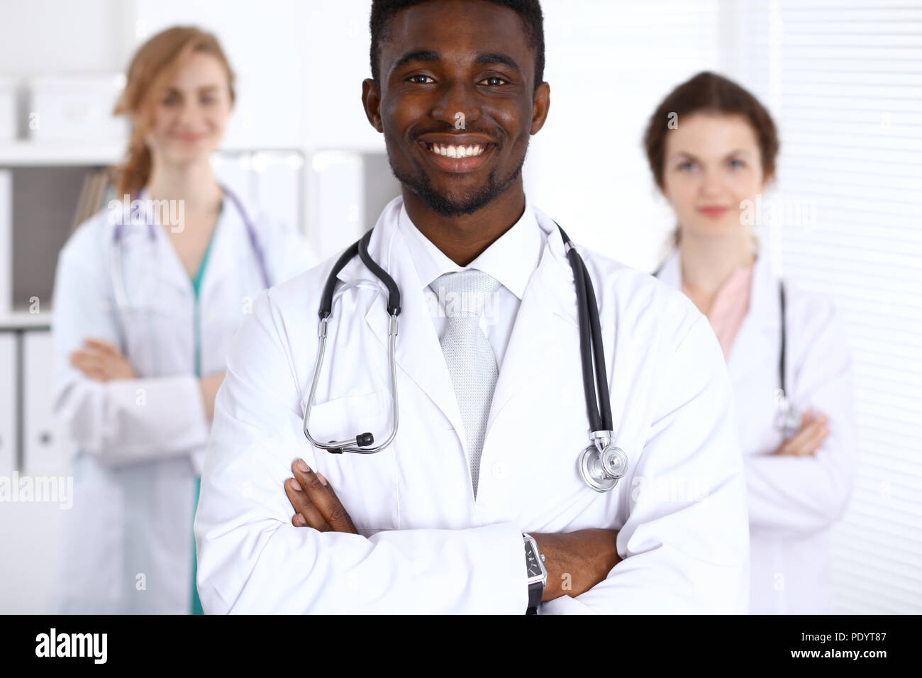 Happy african american male doctor with medical staff at the hospital ...