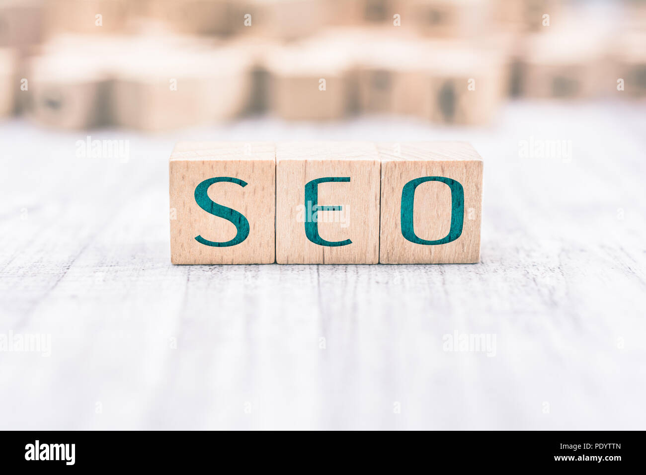 The Word SEO Formed By Wooden Blocks On A White Table Stock Photo