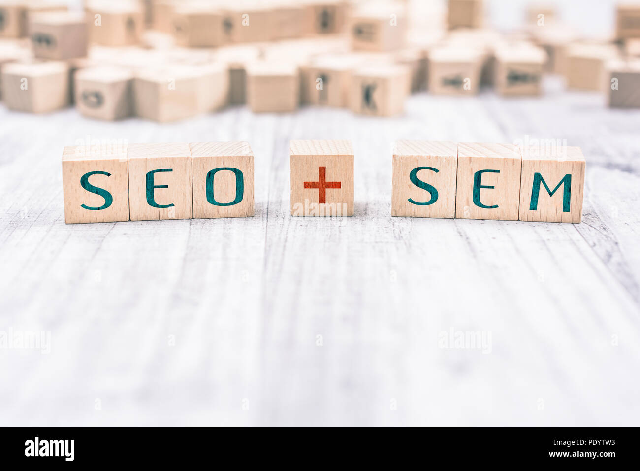 The Words SEO And SEM Formed By Wooden Blocks On A White Table Stock Photo