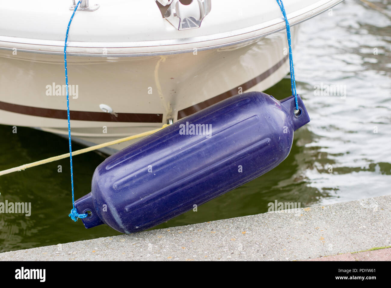 Bumpers hung at the side of the yacht. Moored and secured boats at the