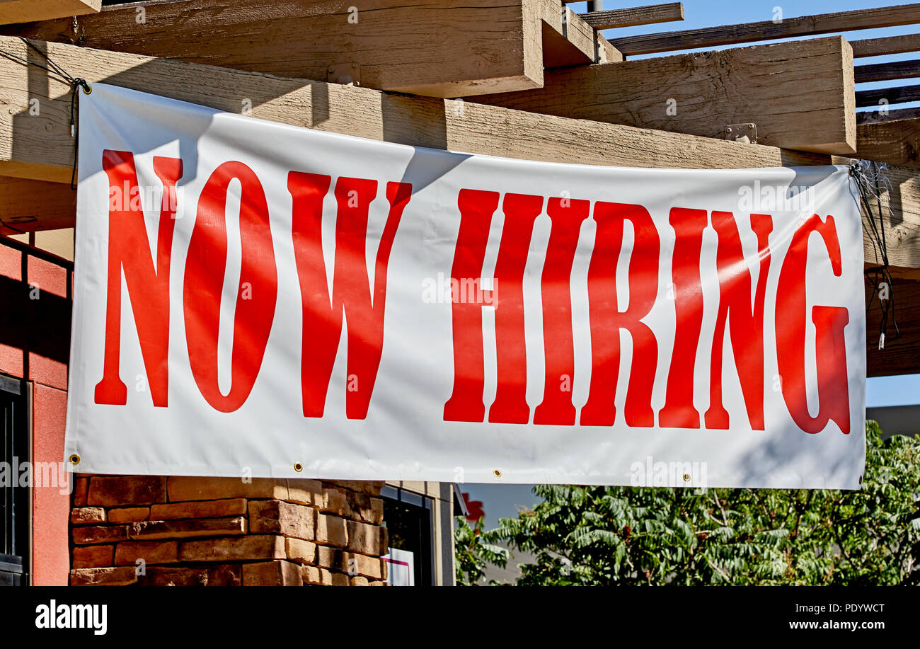 Large now hiring sign posted in the front of a business Stock Photo