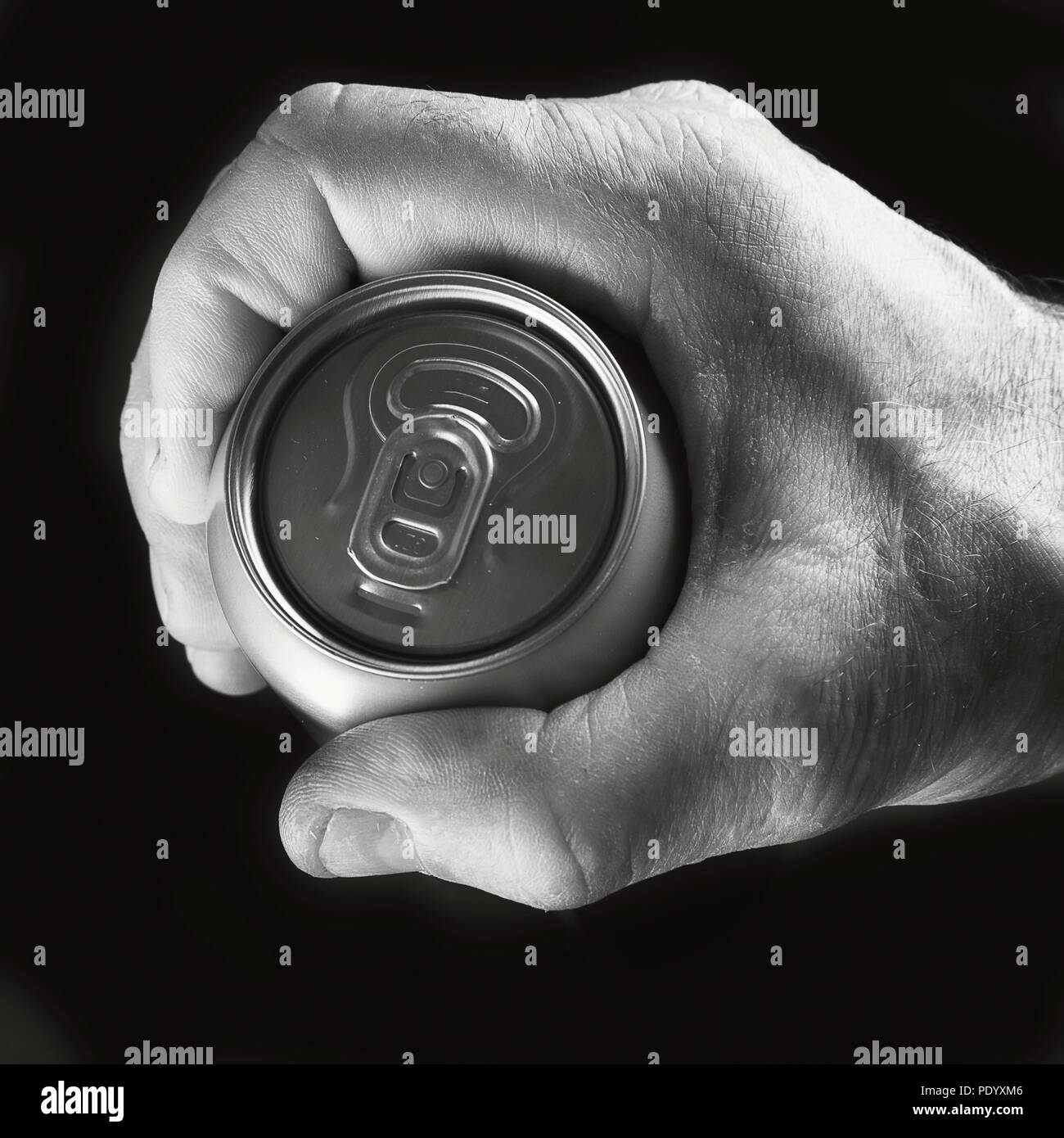 Beer can in hand on black background. Black and white Stock Photo - Alamy