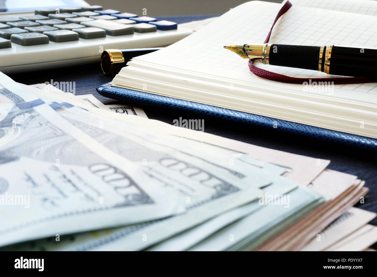 Small business accounting. Pile of money, note and pen. Stock Photo