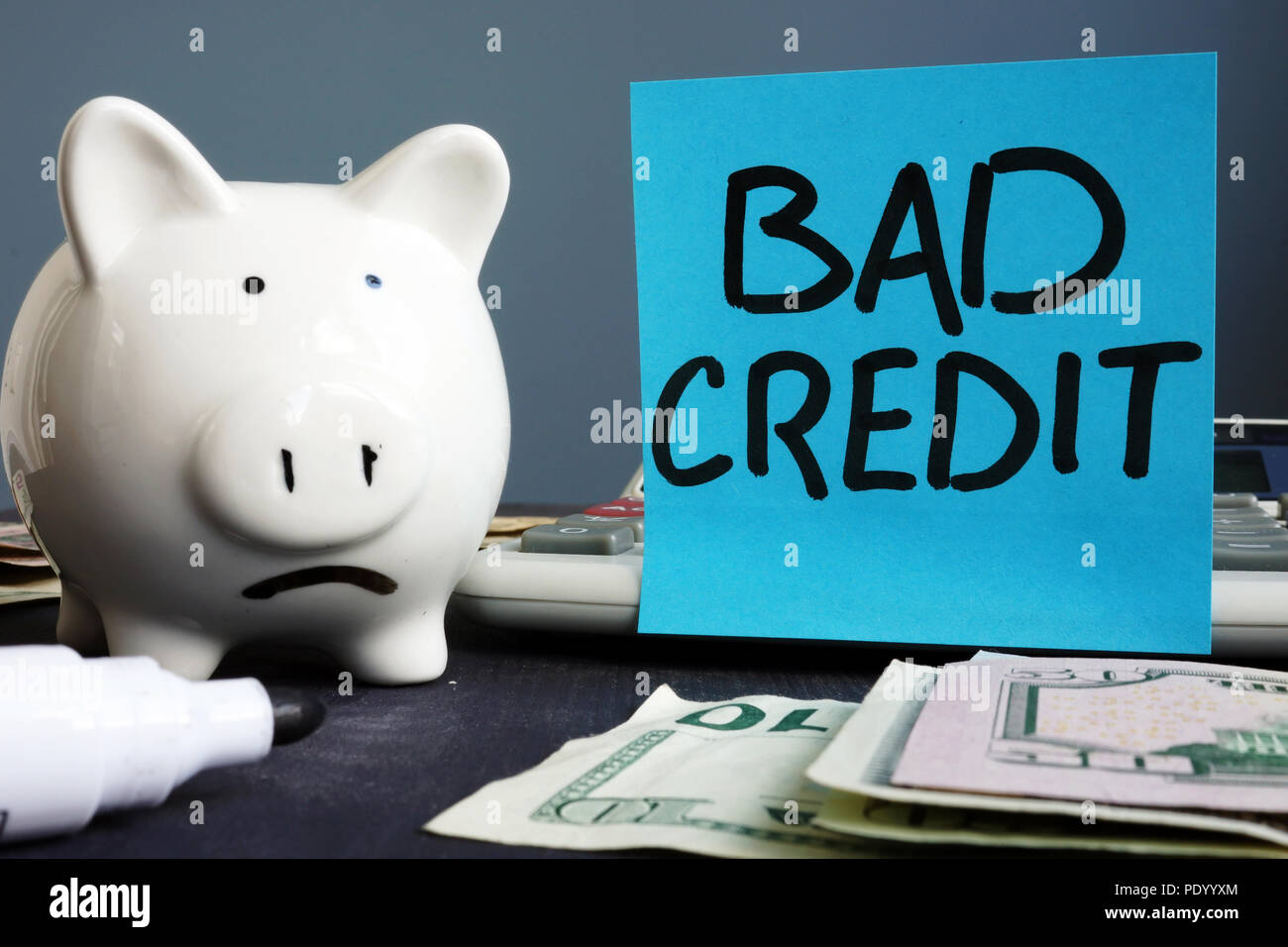 Bad credit. Unhappy piggy bank and calculator. Stock Photo