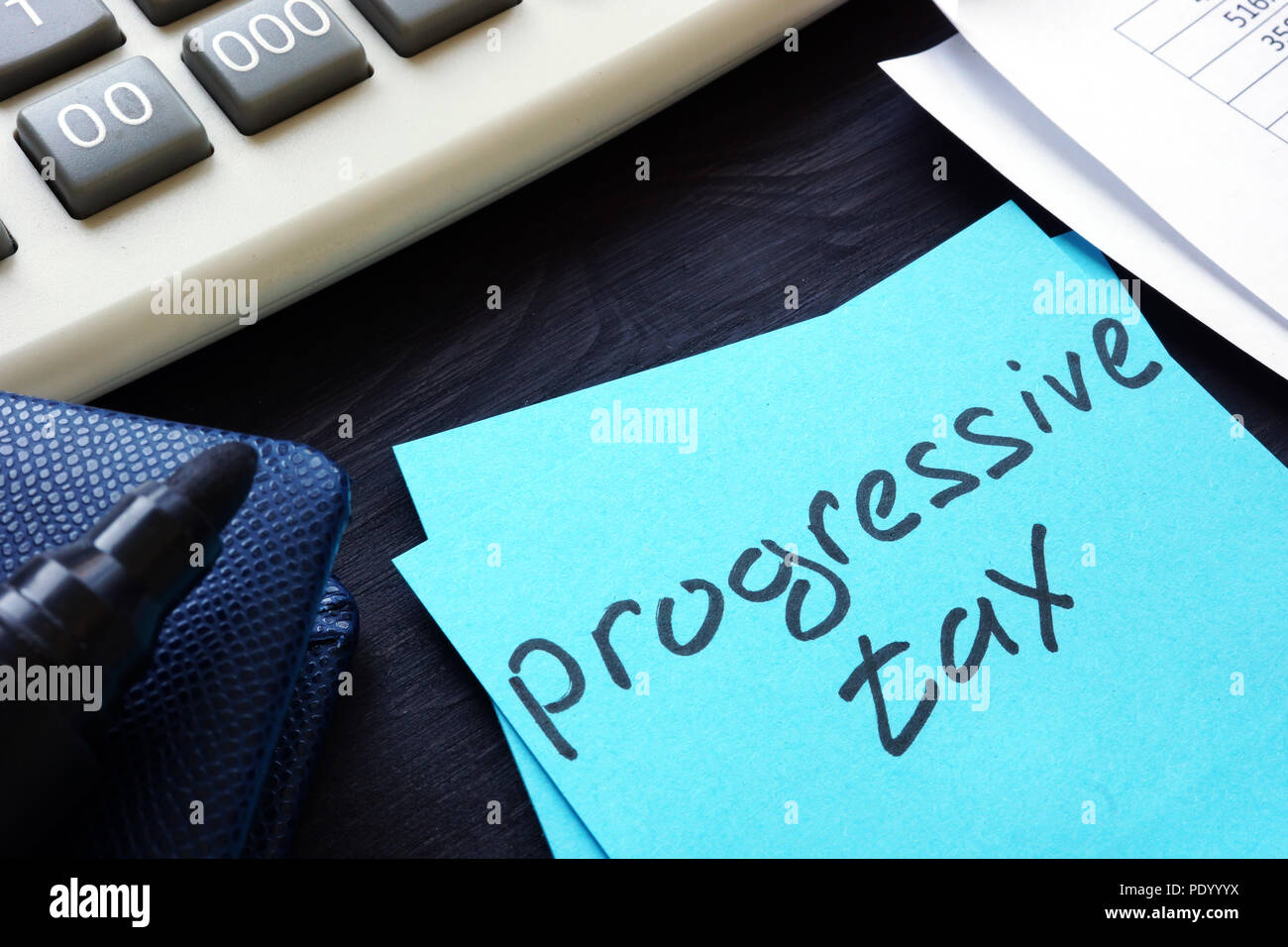 Progressive tax written on a piece of paper. Stock Photo