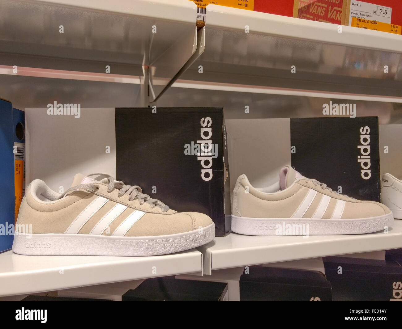 White Adidas sneakers displayed on shelves in shoe store Stock Photo - Alamy