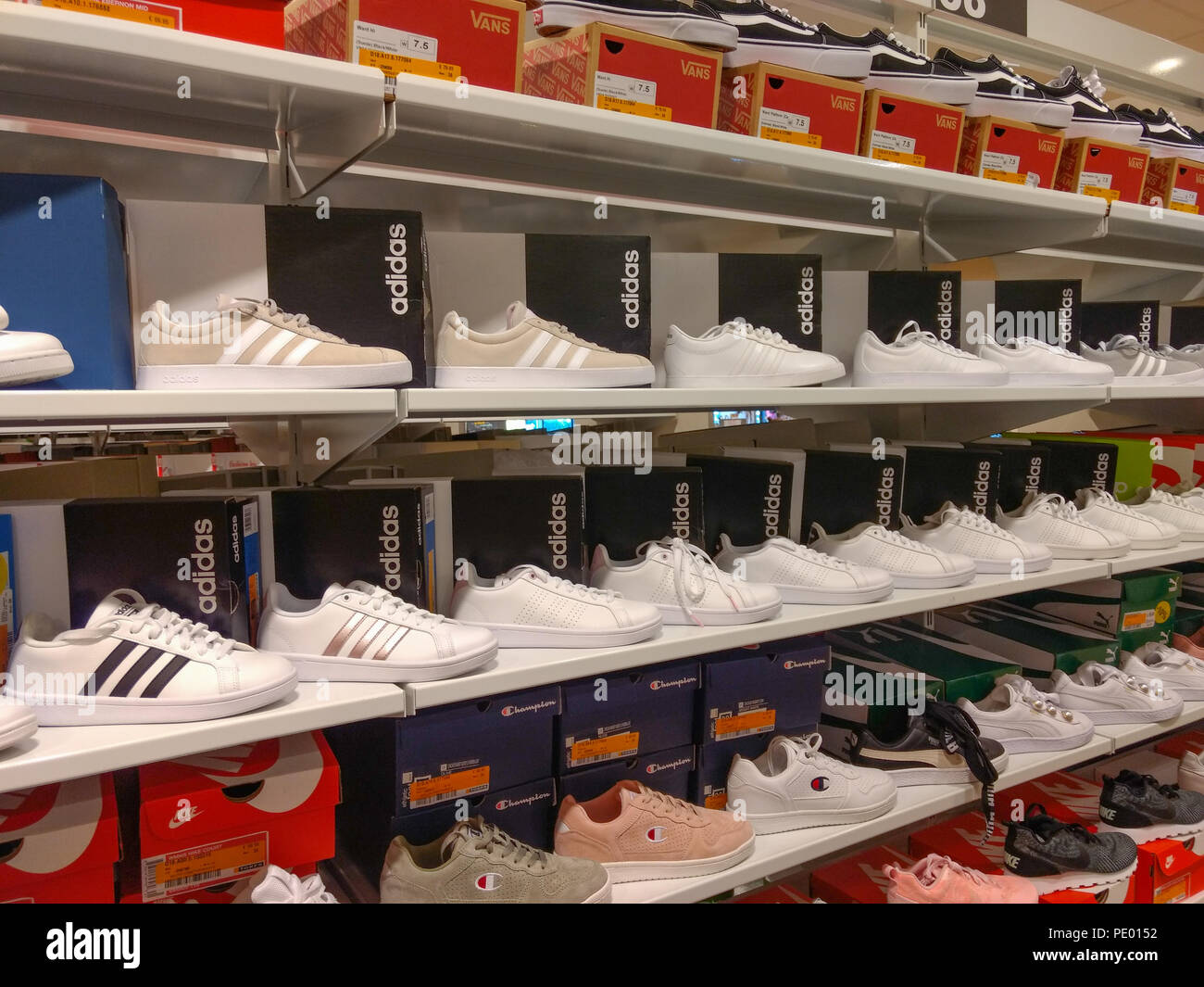 White Adidas shoes displayed on shelves in shoe store Stock Photo - Alamy