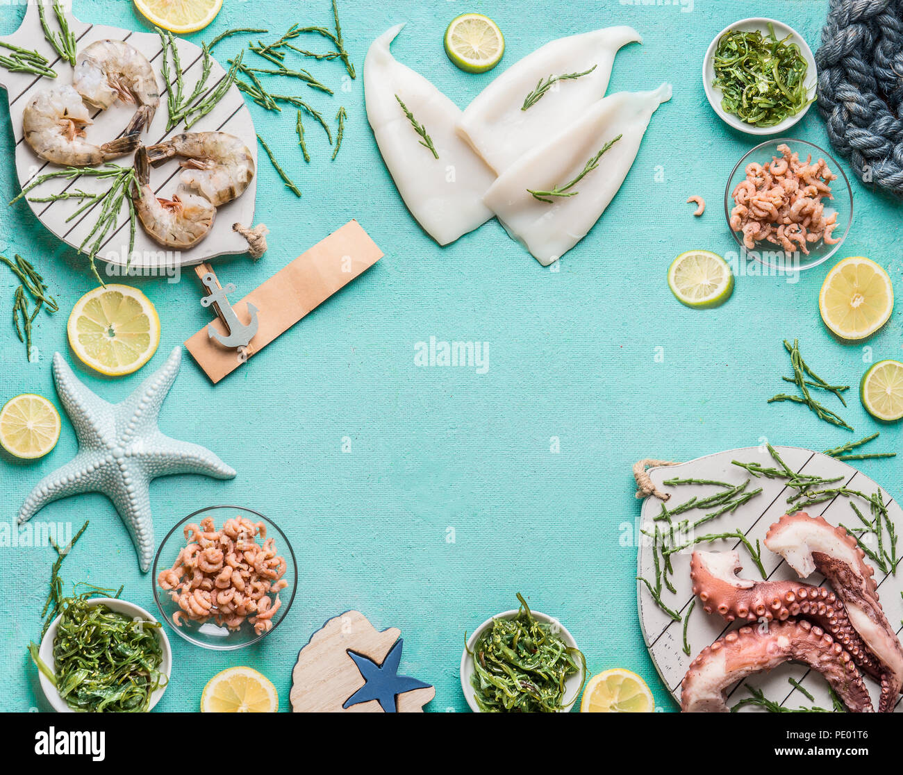 Various seafood on light blue background with squid, prawn or tiger shrimp, octopus, North Sea crabs and seaweed, top view. Place for your design, tex Stock Photo