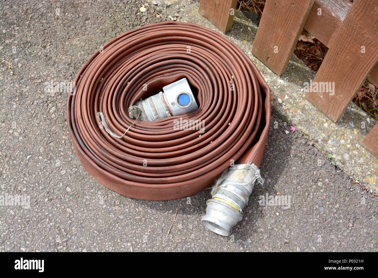 Fire hose length folded into a coil Stock Photo