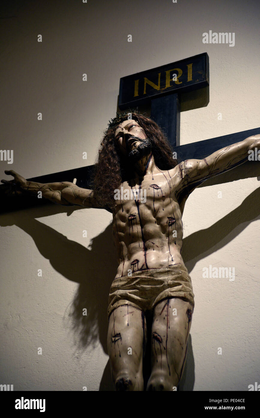 A wooden Crucifix mounted on a wall in the Cathedral Basilica of St. Francis of Assisi in Santa Fe, New Mexico Stock Photo