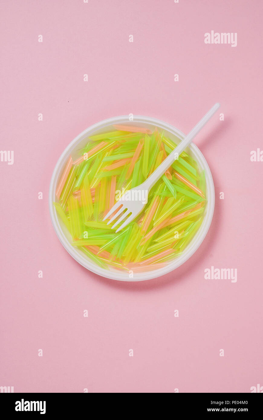 Plate and fork of plastic on a pink background Stock Photo
