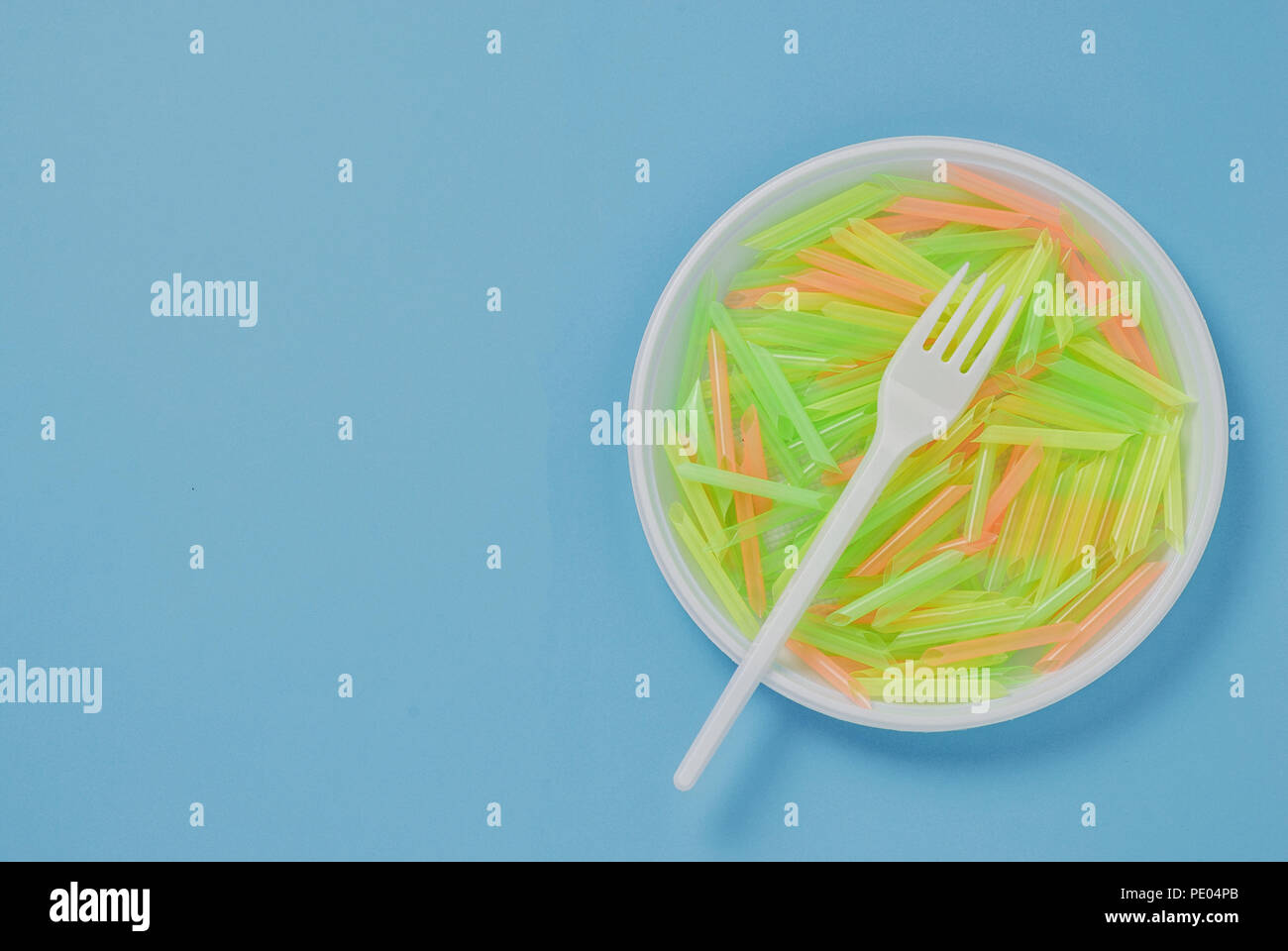 Plate and fork of plastic on a blue background Stock Photo