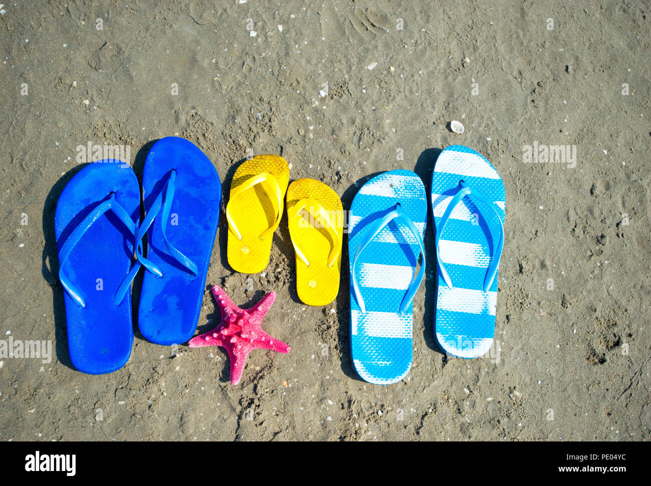 Color Flip flops on the sandy Stock Photo - Alamy