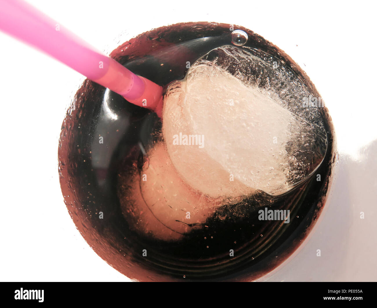 Close up of ice cubes and plastic straw in glass of coke Stock Photo
