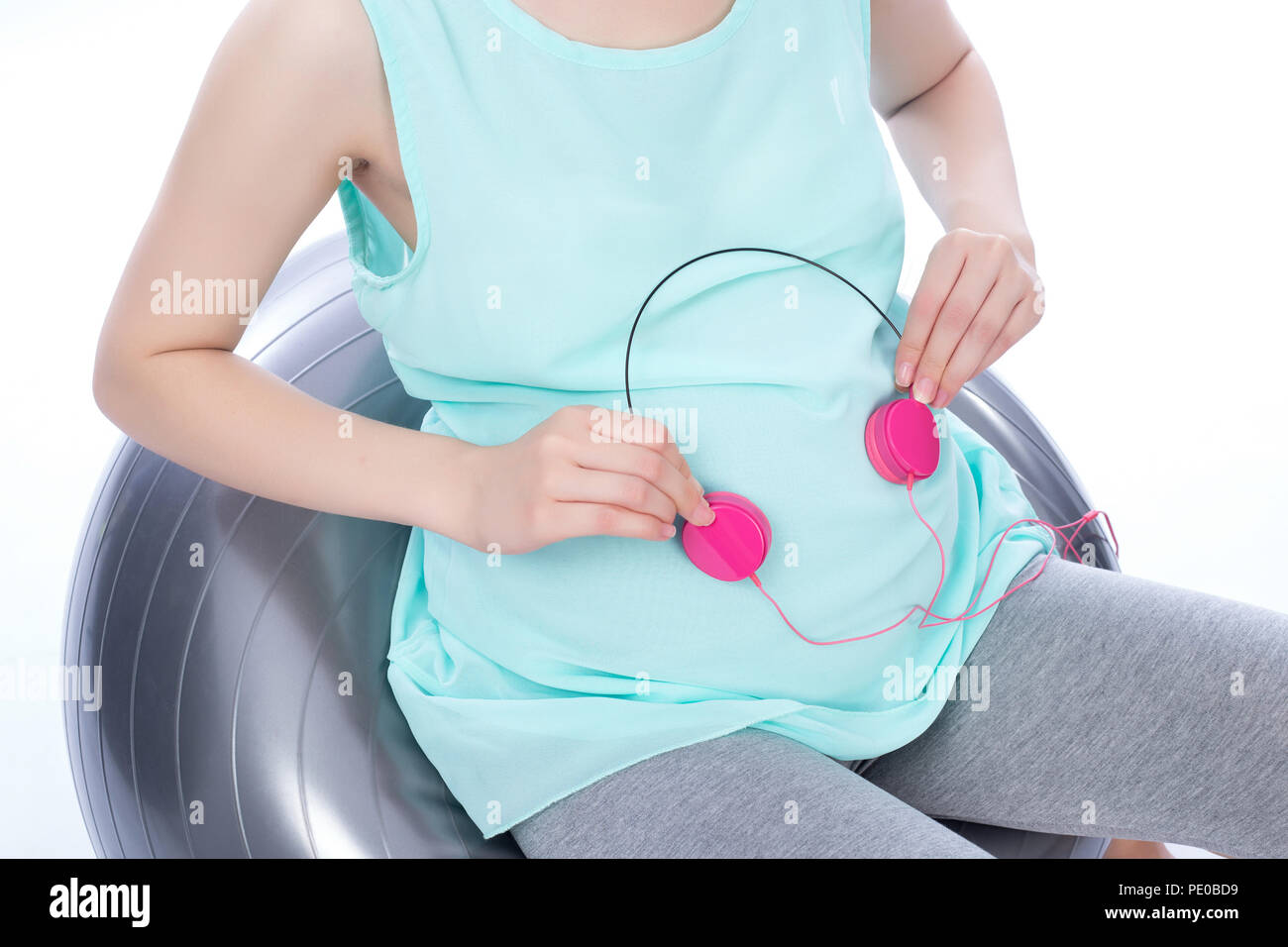 Pregnant woman holding headphones on belly Stock Photo Alamy