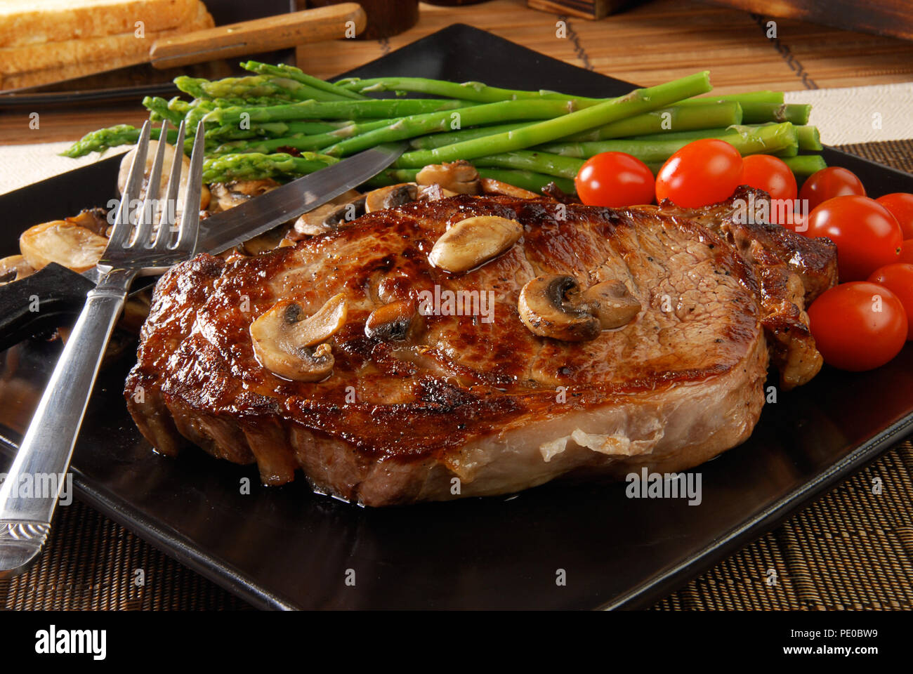 A juicy steak with sauteed mushrooms, cherry tomatoes and asparagus