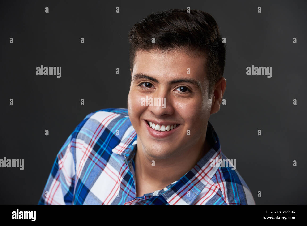 Headshot portrait of young smiling brunette man in studio background ...