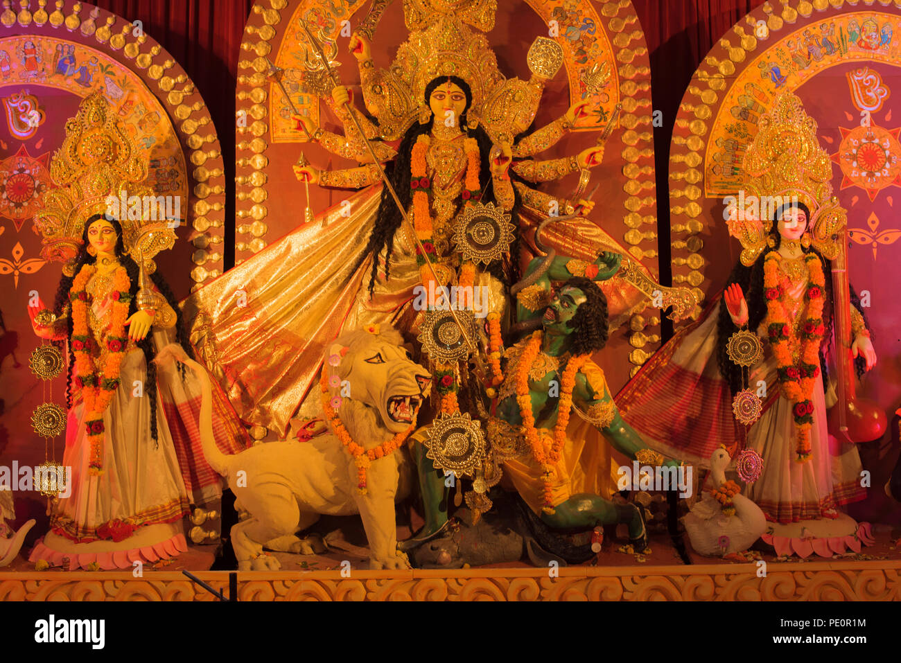 An idol of Hindu Goddess Durga in the center slaying demon Mahishasura thus protecting and safeguarding her devotees from the evil and wicked forces Stock Photo