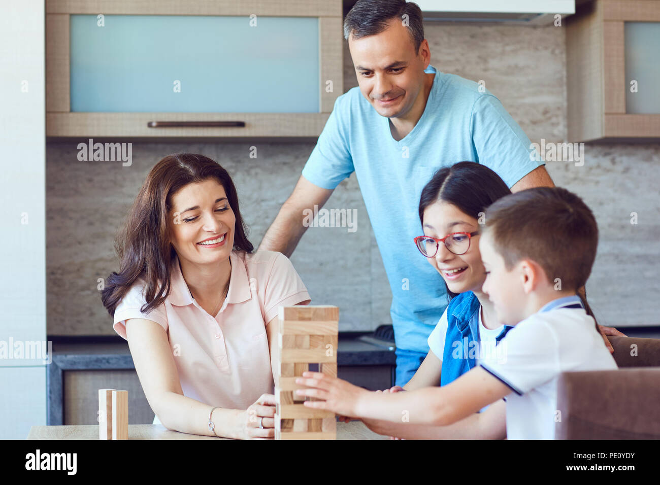 Family playing a board game at a table. Stock Photo