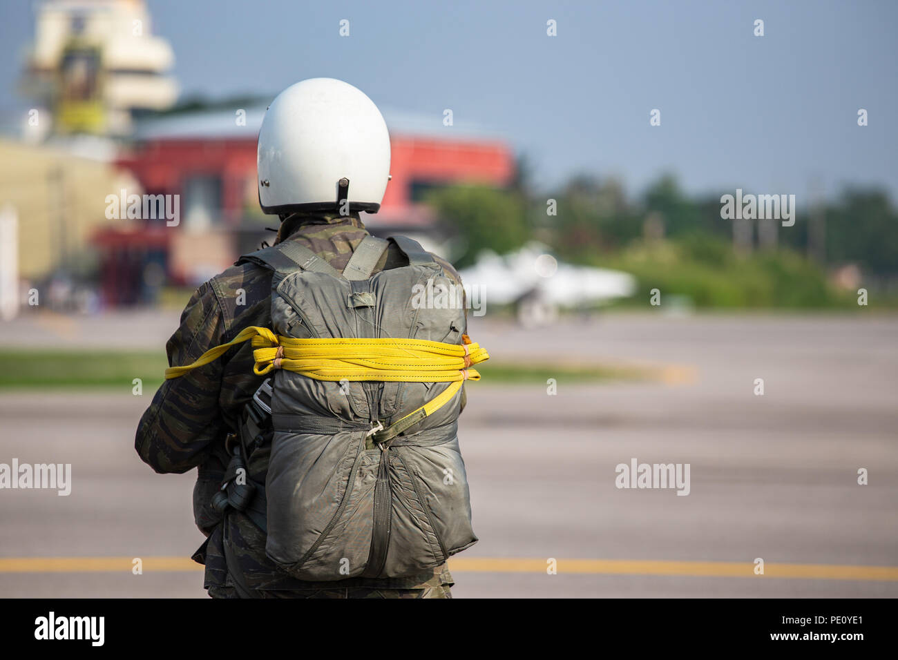 Police paratrooper in camouflage uniform and helmet with T-10 static line parachute  and equipment standby at airfield with copy space Stock Photo