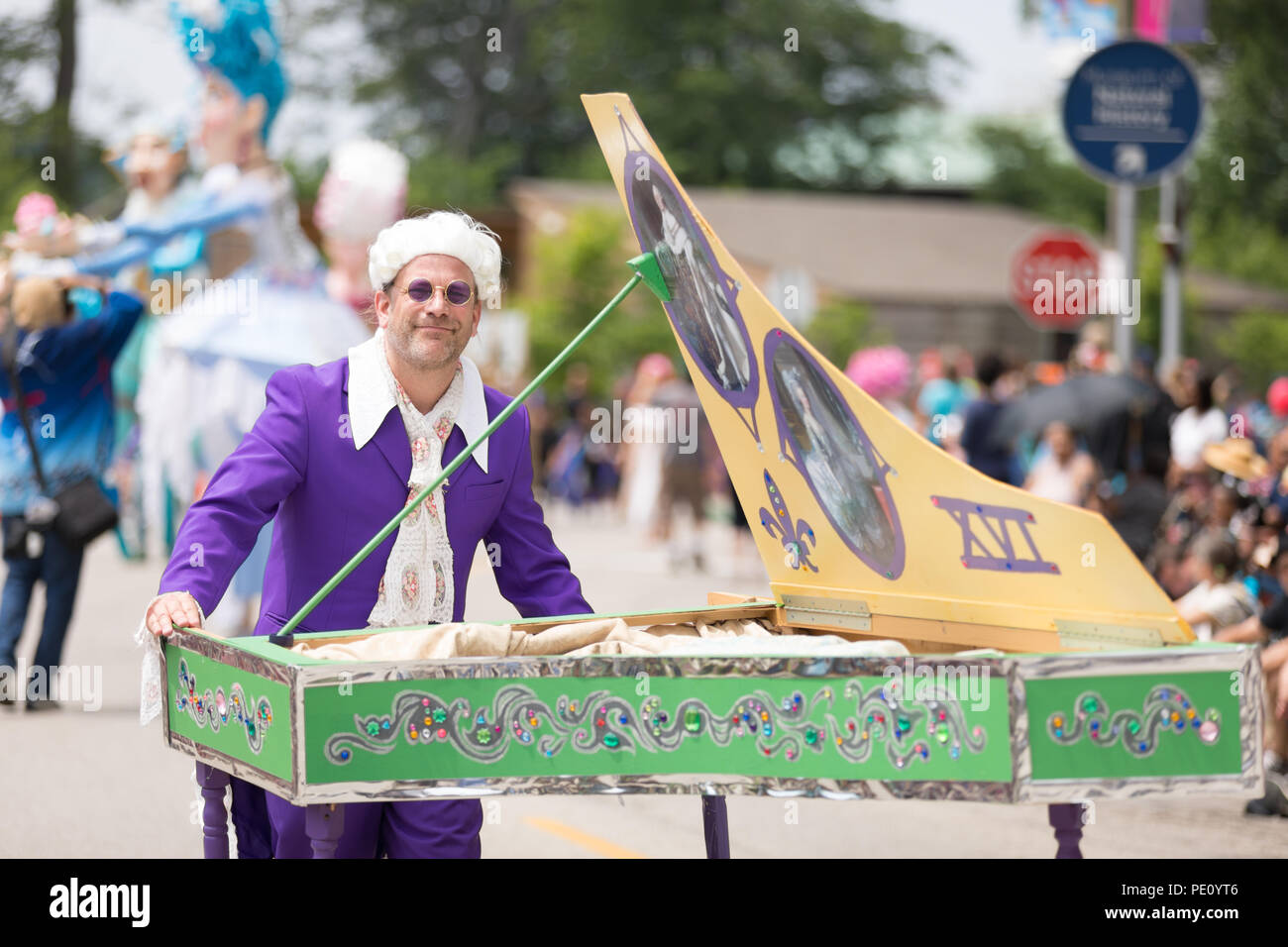Cleveland, Ohio, USA - June 9, 2018 man pretends to play the piano wearing a white wig and purple glasses At the abstract art festival Parade The Circ Stock Photo