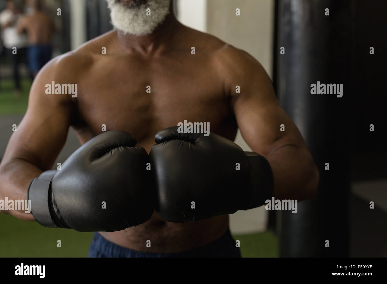 Senior man in black boxing gloves Stock Photo