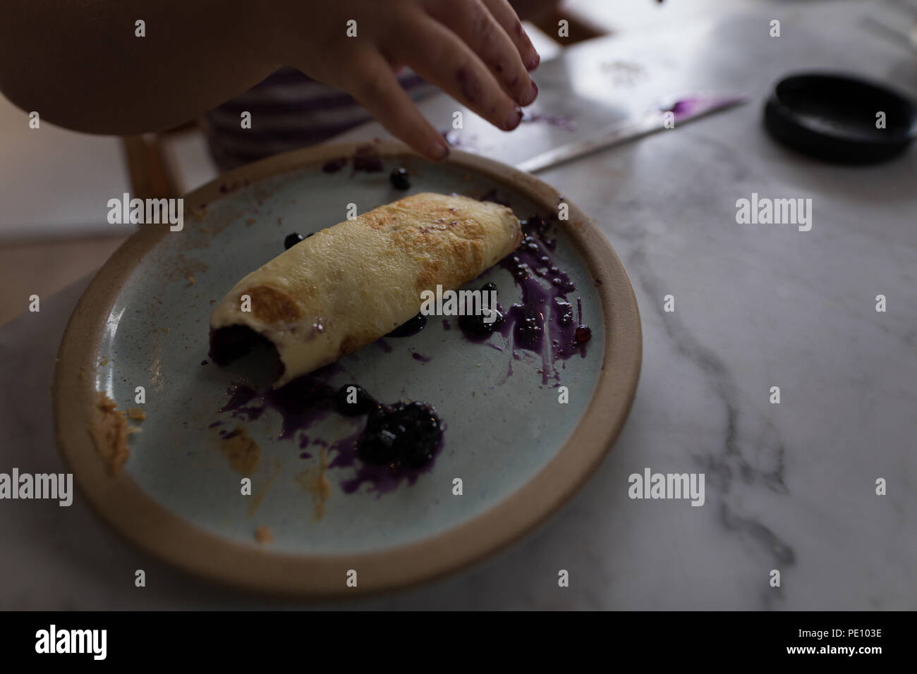 Baby girl eating jam roll at home Stock Photo Alamy