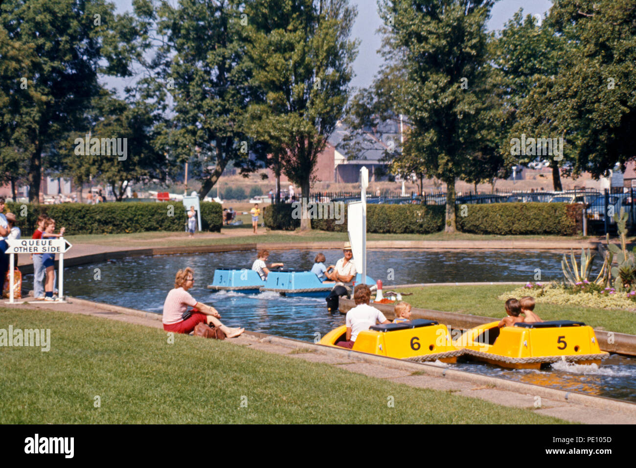 Young mother watching children in boating lake, Nicholas Everett Park, Oulton Broad, Suffolk, England, 1975 Stock Photo