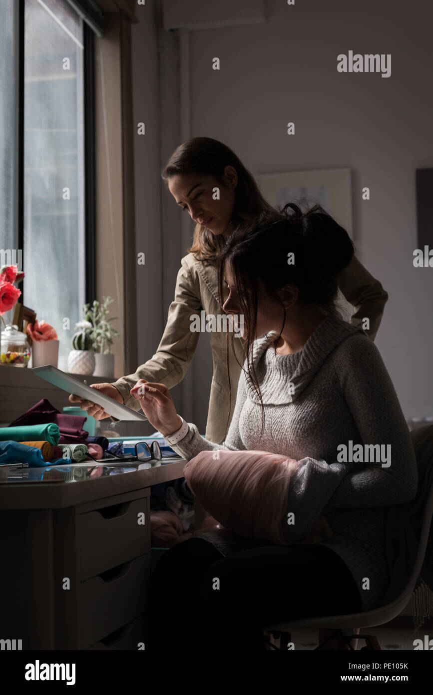 Fashion designers discussing over laptop Stock Photo