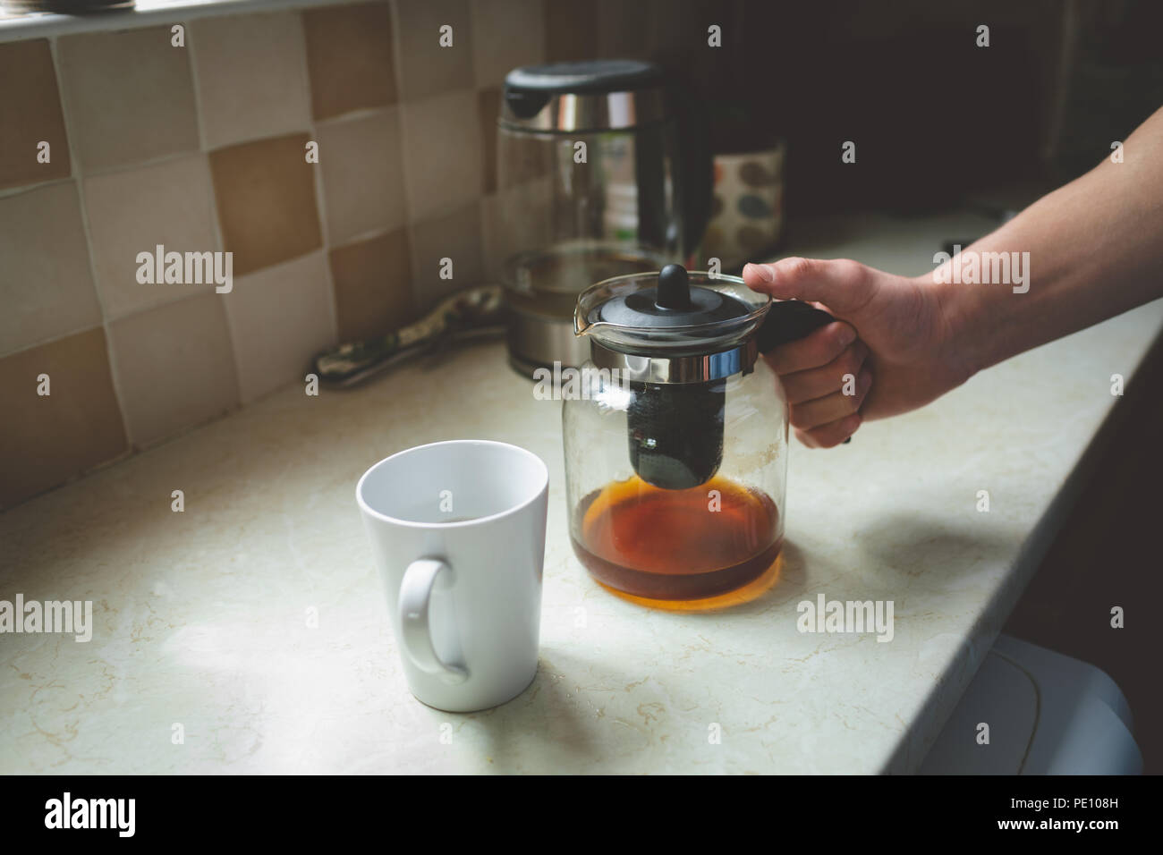 Coffee filter jar and mug on kitchen worktop Stock Photo