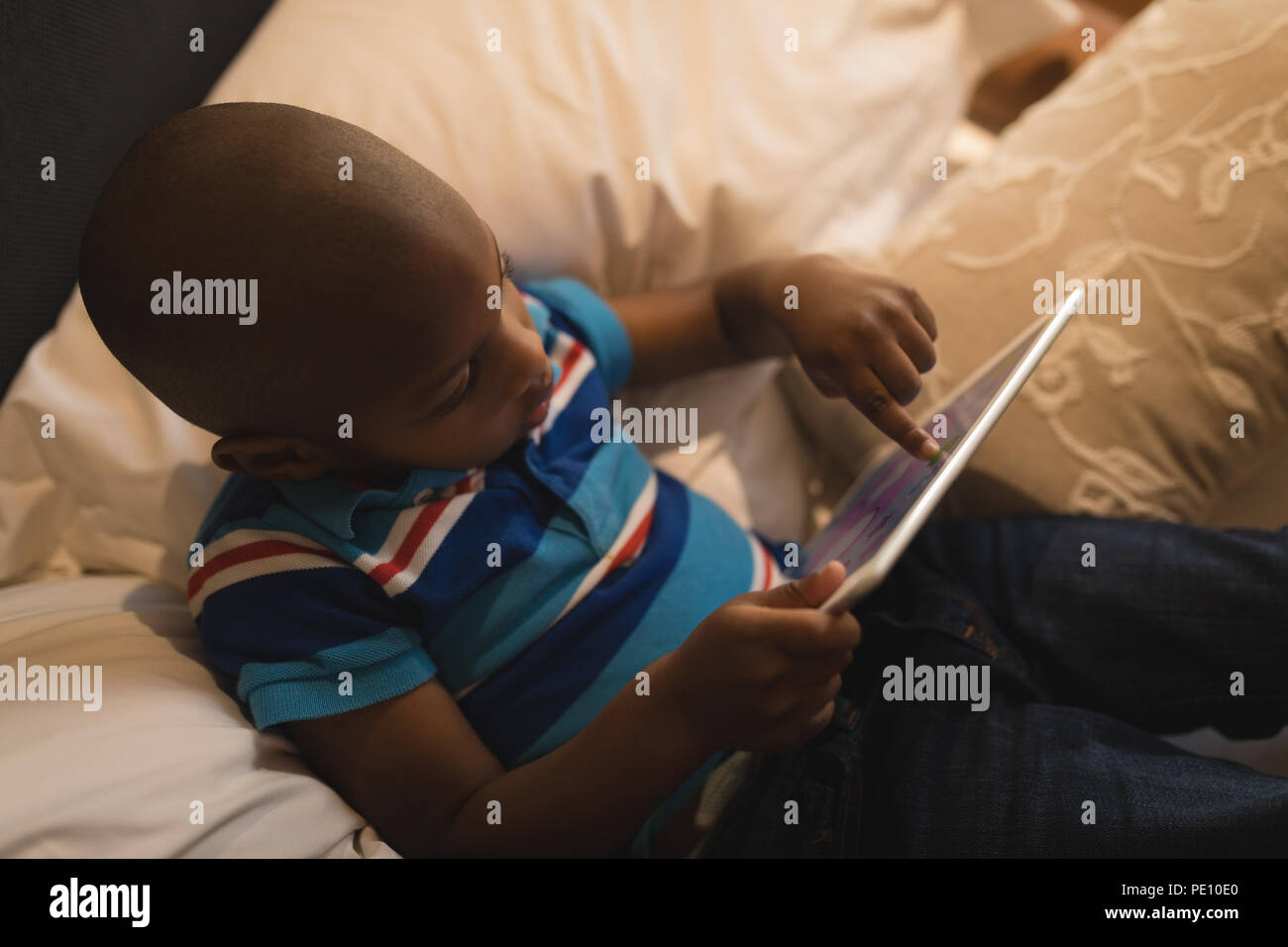 Boy playing with digital tablet in bedroom Stock Photo
