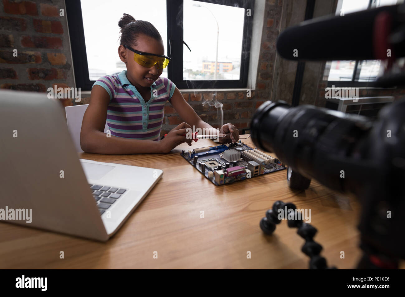 Teenage blogger soldering a circuit board Stock Photo