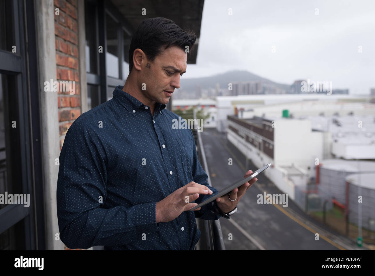 Businessman using digital tablet in balcony Stock Photo