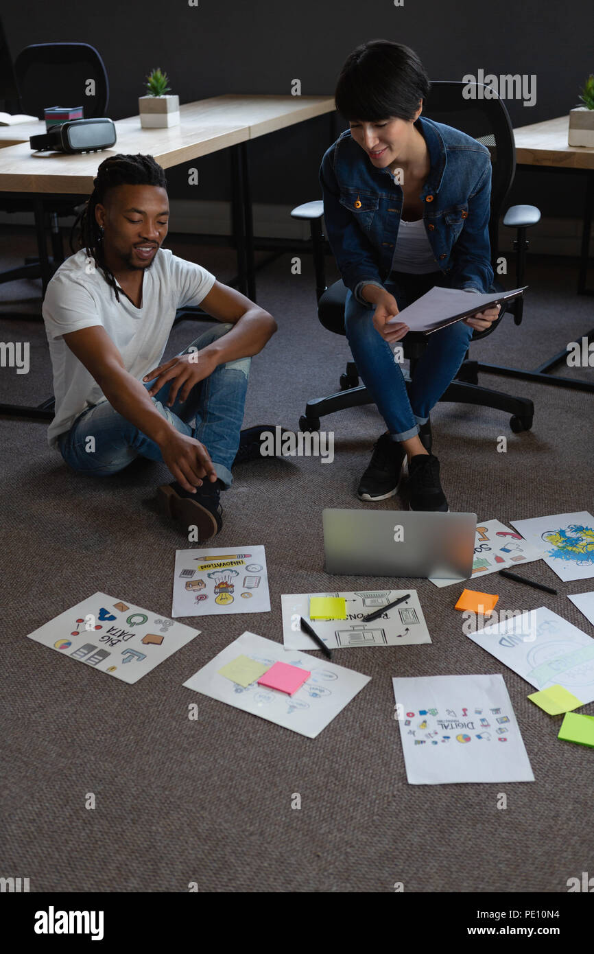 Colleagues discussing over documents Stock Photo