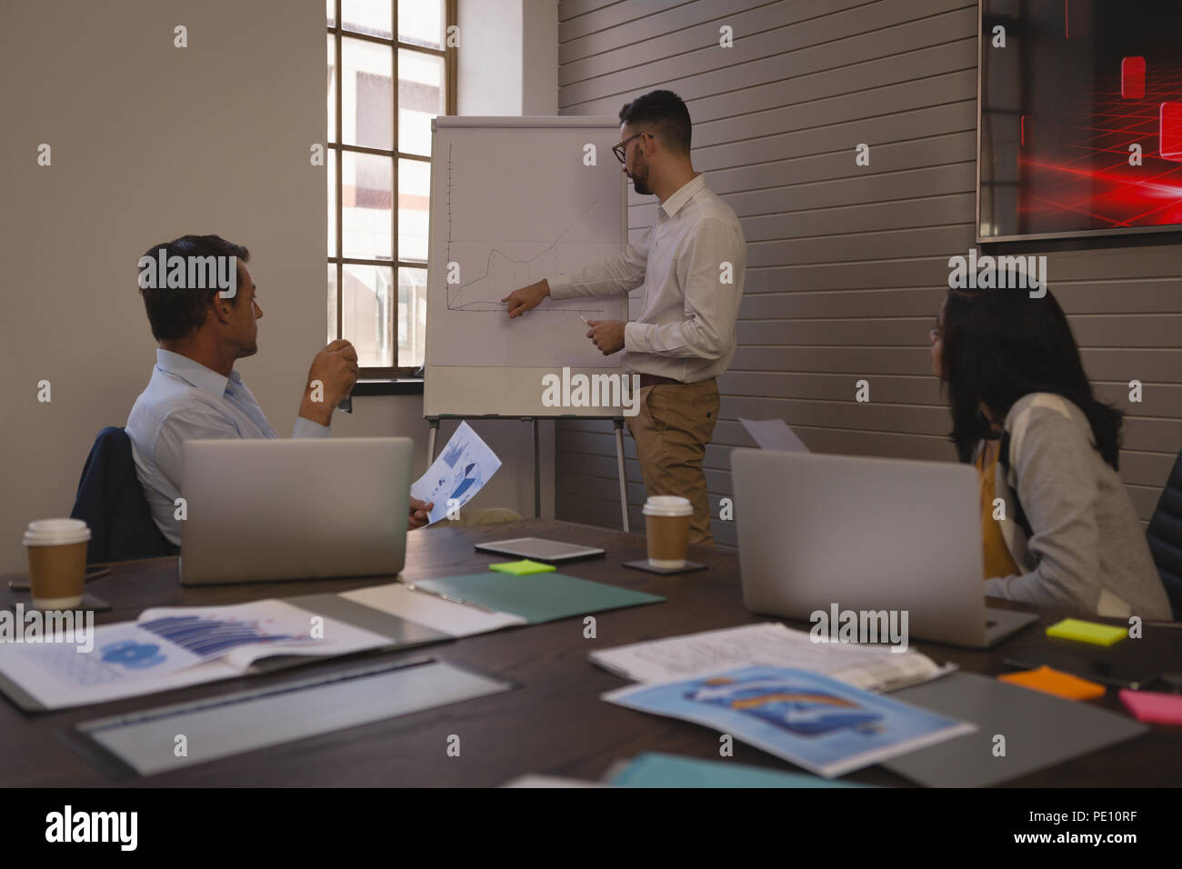 Businessman giving a presentation on whiteboard chart in the conference room Stock Photo