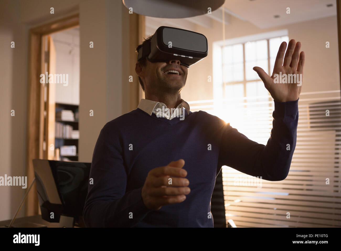 Businessman using virtual reality headset in the office Stock Photo