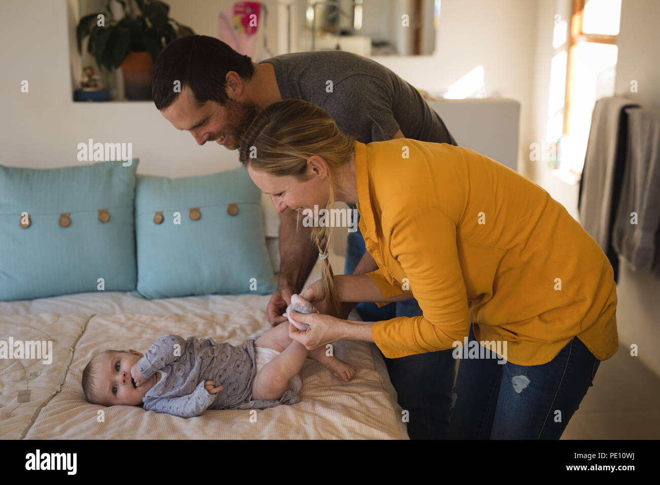 Parents changing diaper of their baby boy Stock Photo