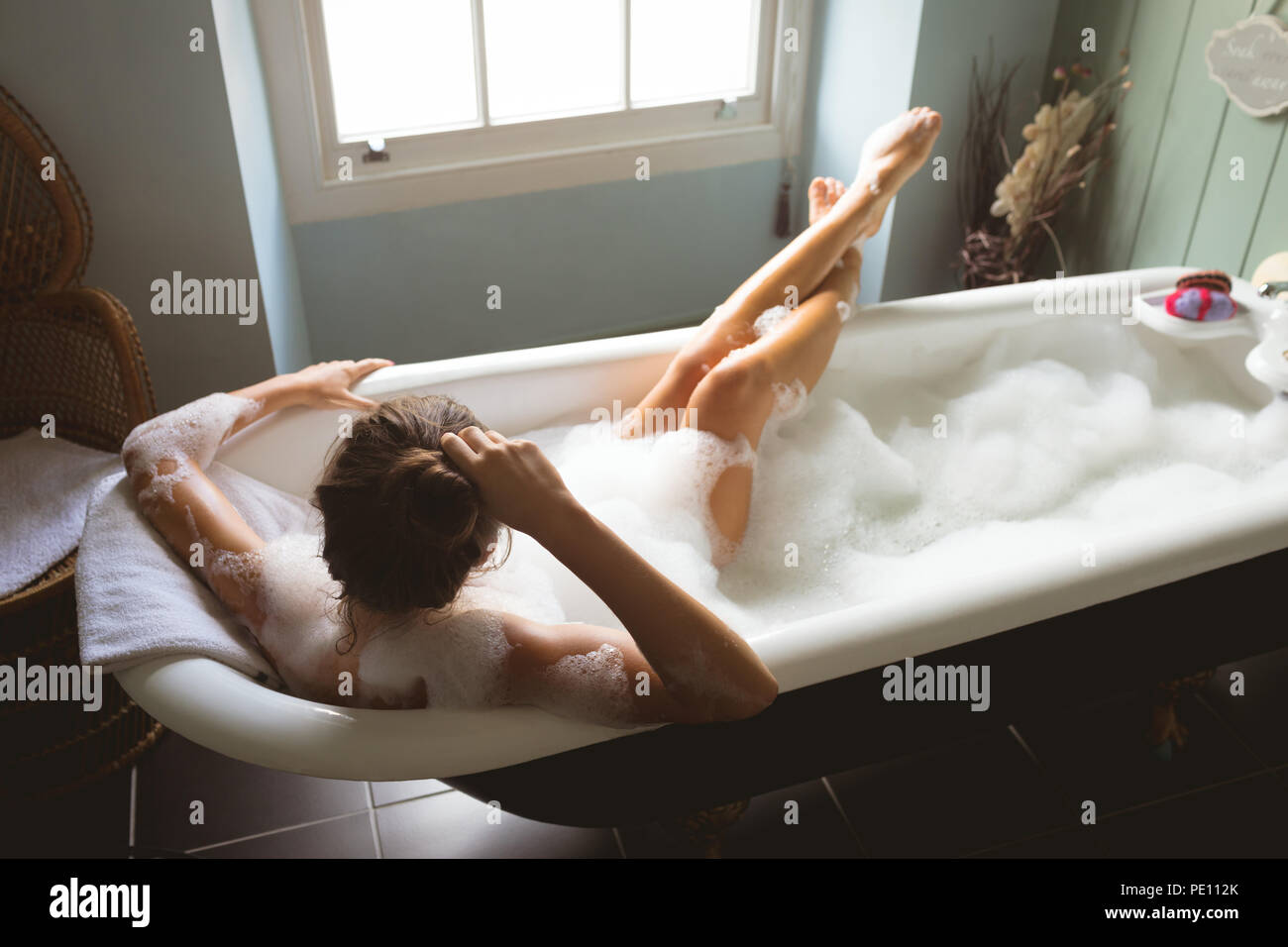 Woman taking a bath in bath tub Stock Photo