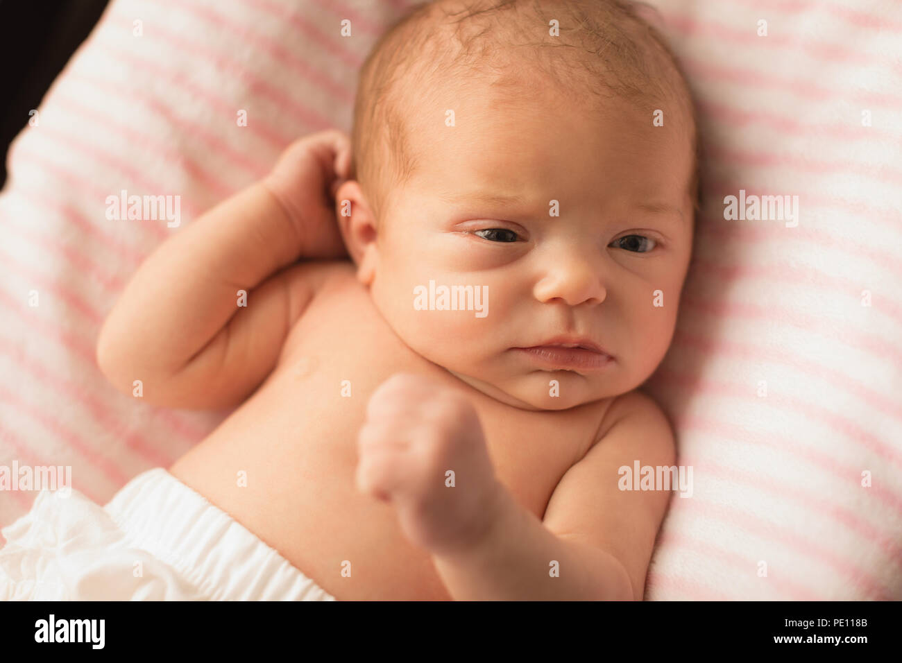 Newborn baby relaxing on baby bed Stock Photo Alamy