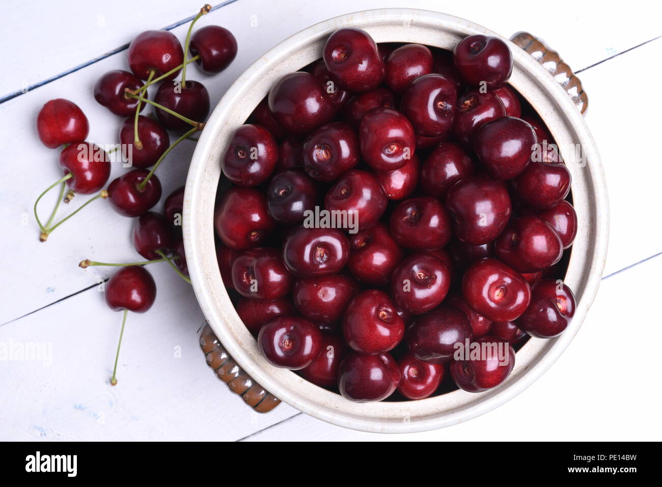 Fresh sweet cherry in bowl on wooden background top view Stock Photo