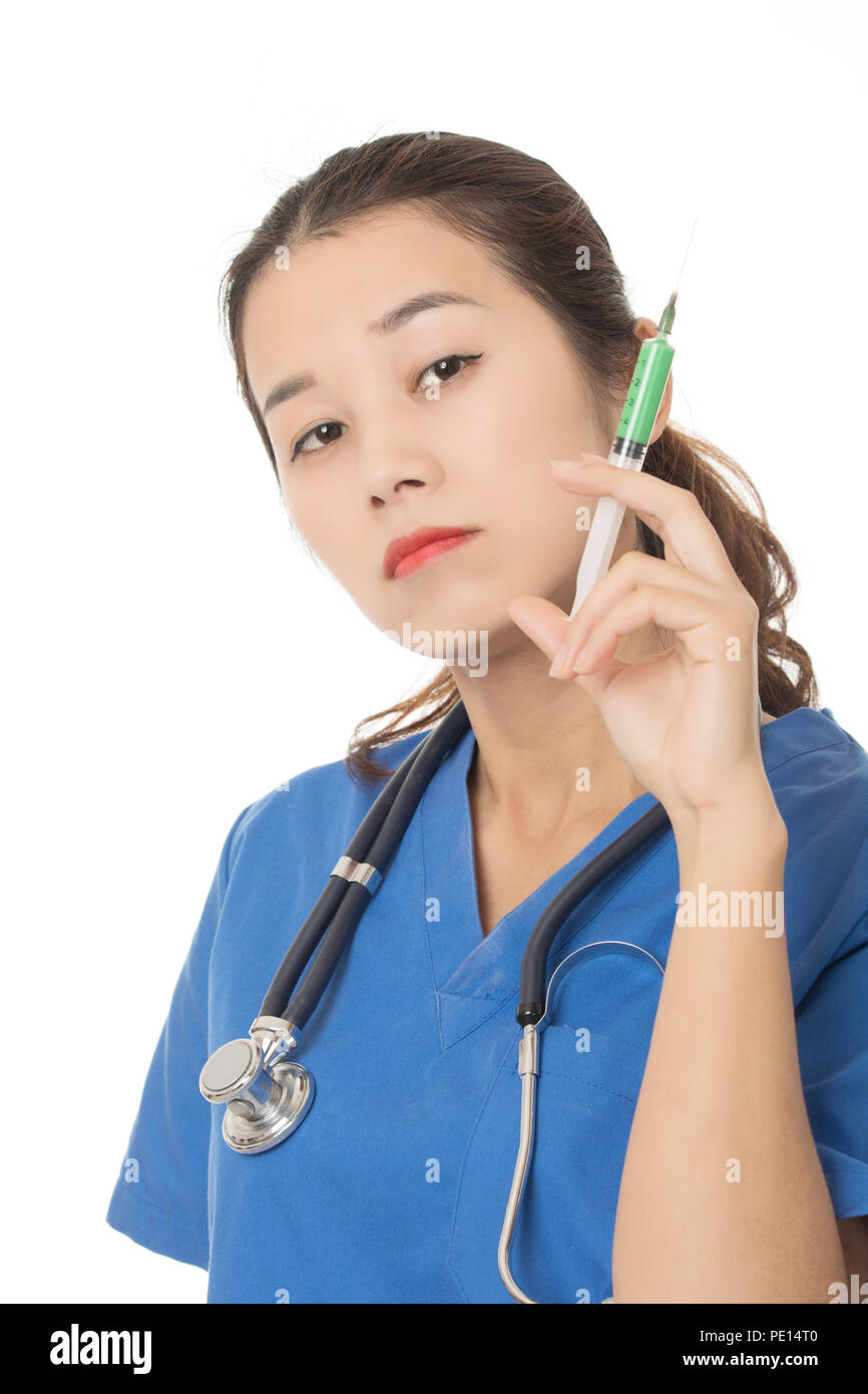 Evil Asian doctor or nurse holding a syringe filled with green medication isolated on a white background Stock Photo