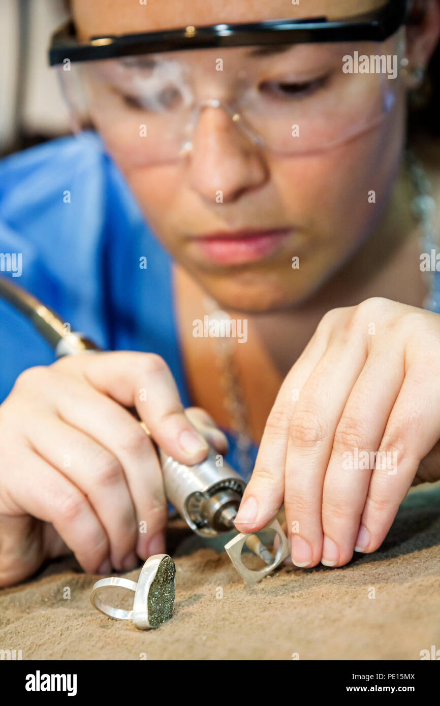 Miami Beach Florida,jewelry jewellery making,adult education class woman female wearing safety goggles,rotary tool ring handmade polishing hobby Stock Photo